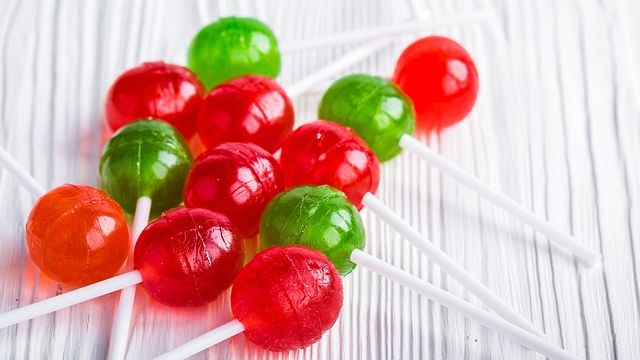 Collection of red and green lollipops laying on a table. 