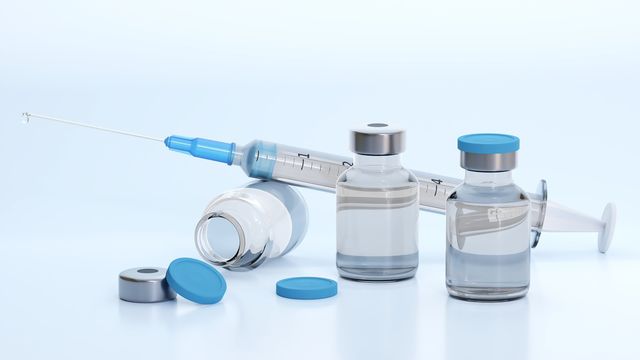 Vaccine vials and hypodermic needle.  