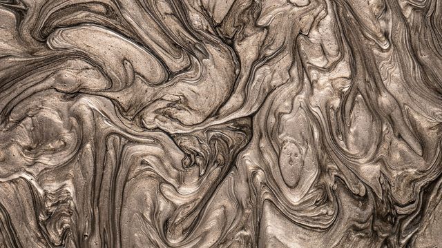 Liquid, chrome-colored metal makes swirling patterns. 