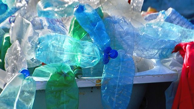 Single-use plastic waste overflowing from a bin. 