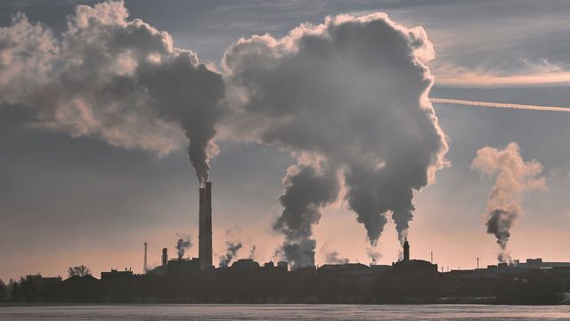 Chimneys release dark clouds into the sky. 